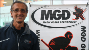Man standing beside Magic Goalie Development banner.