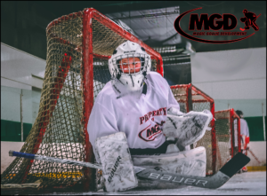 Young hockey goalie in full gear ready in front of the net.